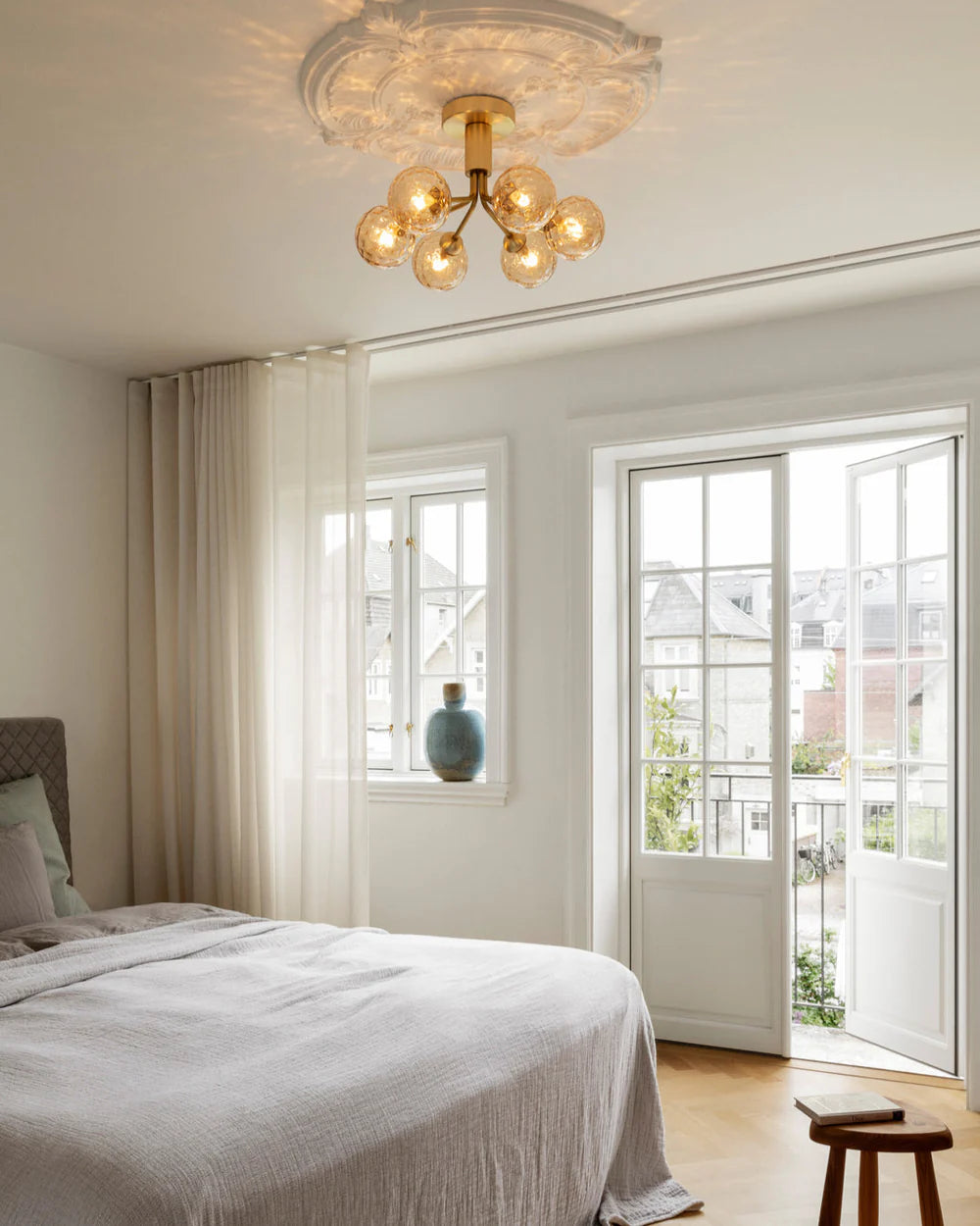 Modern ceiling chandelier from Nuura with patterned glass domes and matte black finish, suitable for stylish low-ceilinged rooms.

