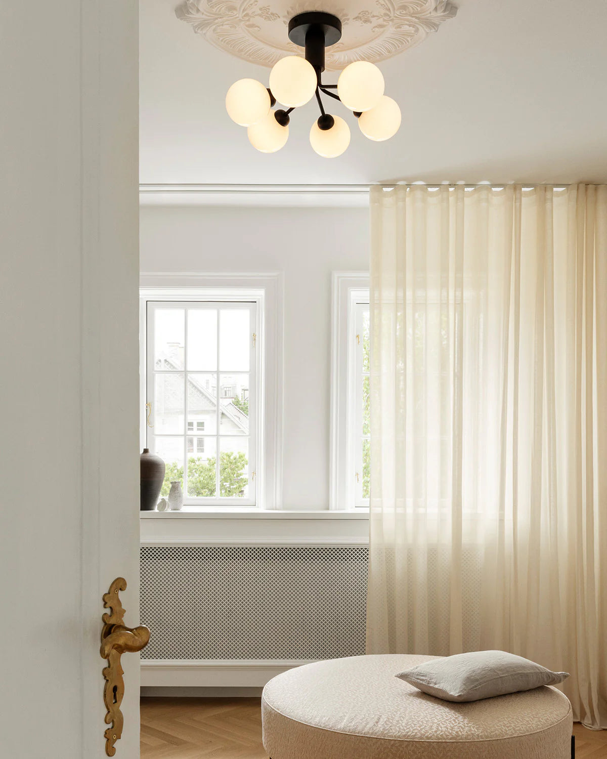 Modern ceiling chandelier from Nuura with patterned glass domes and matte black finish, suitable for stylish low-ceilinged rooms.

