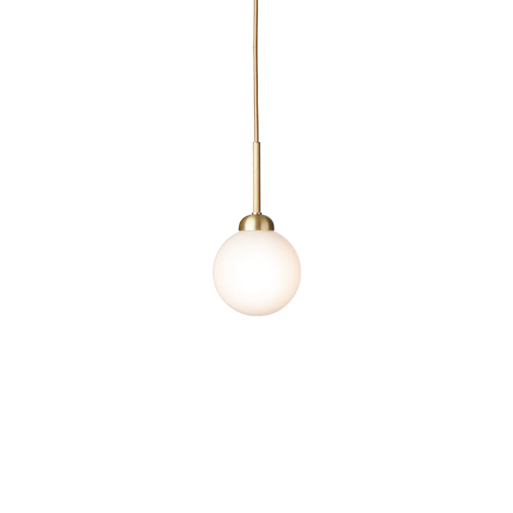 Apiales 1 pendant lamp by Nuura with opal white glass shade and brushed brass details, suspended by a gold fabric-covered cord.







