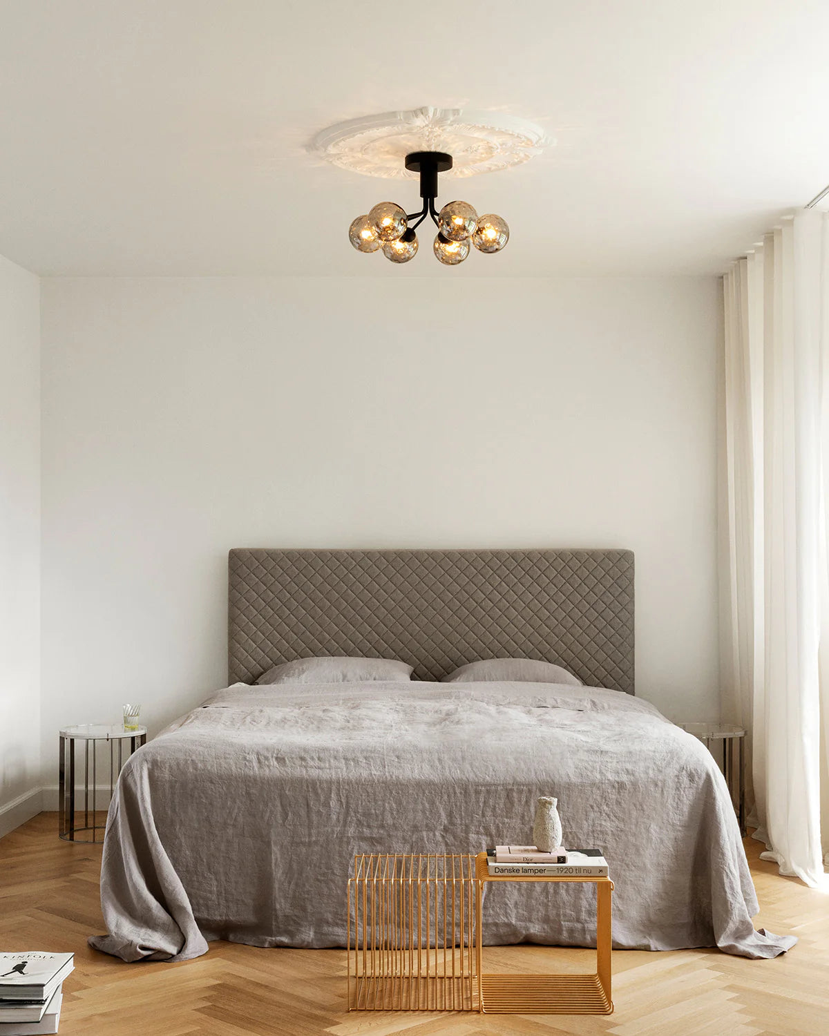 Modern ceiling chandelier from Nuura with patterned glass domes and matte black finish, suitable for stylish low-ceilinged rooms.

