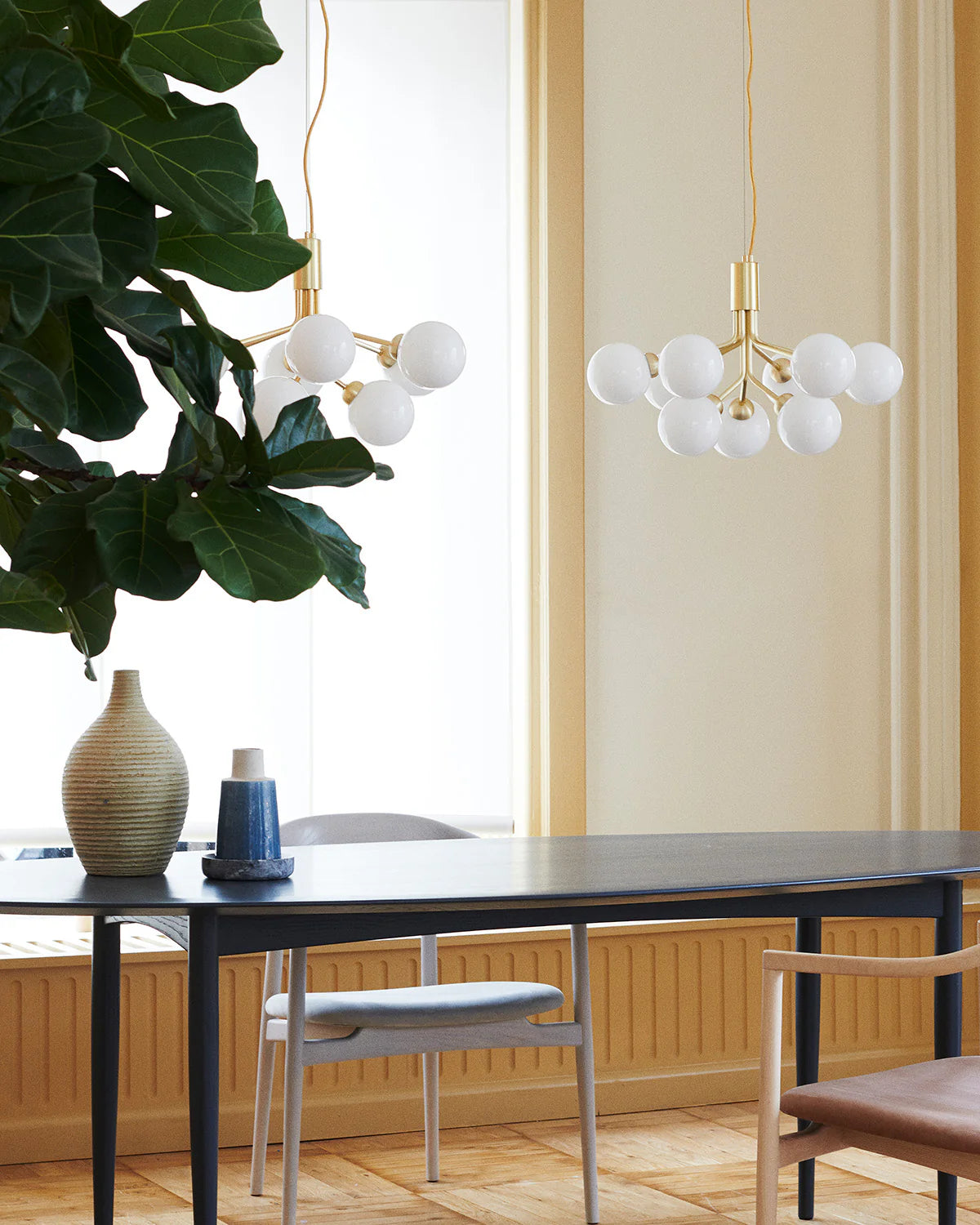 Nuura Apiales 9 chandelier with satin black arms and nine smoked glass shades, designed for modern interiors with elegant, ambient lighting.







