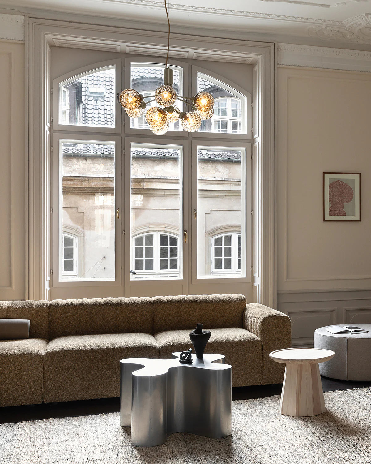 Nuura Apiales 9 chandelier with satin black arms and nine smoked glass shades, designed for modern interiors with elegant, ambient lighting.







