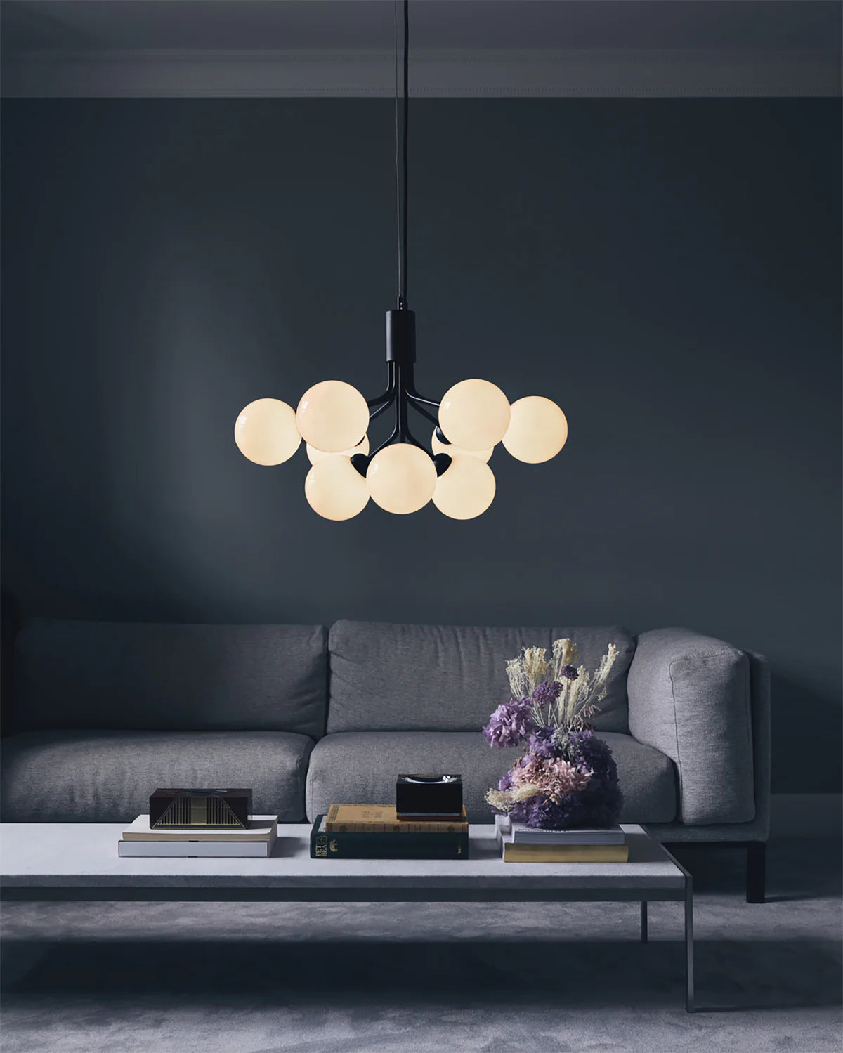 Nuura Apiales 9 chandelier with satin black arms and nine smoked glass shades, designed for modern interiors with elegant, ambient lighting.








