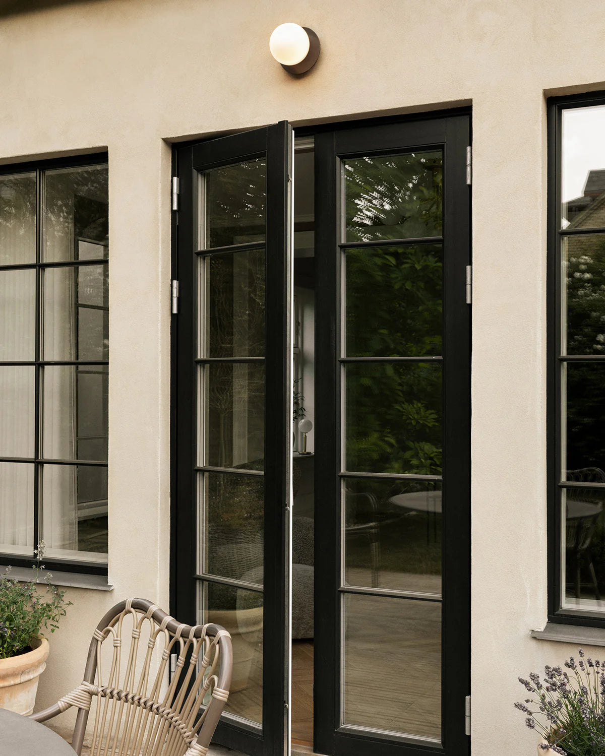 Nuura Liila 1 Outdoor Wall Lamp with bronze finish and clear glass globe, ideal for stylish outdoor wall or ceiling lighting in modern exterior spaces.