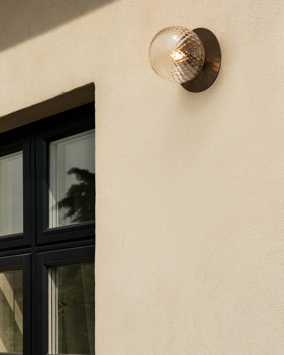 Nuura Liila 1 Outdoor Wall Lamp with bronze finish and clear glass globe, ideal for stylish outdoor wall or ceiling lighting in modern exterior spaces.