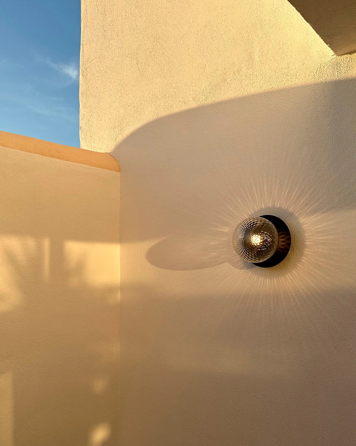 Nuura Liila 1 Outdoor Wall Lamp with bronze finish and clear glass globe, ideal for stylish outdoor wall or ceiling lighting in modern exterior spaces.