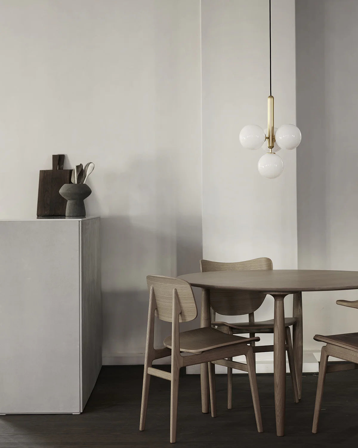 Four-light Scandinavian pendant lamp by Nuura, featuring brass frame and white glass shades for living room , dining room or kitchen lights