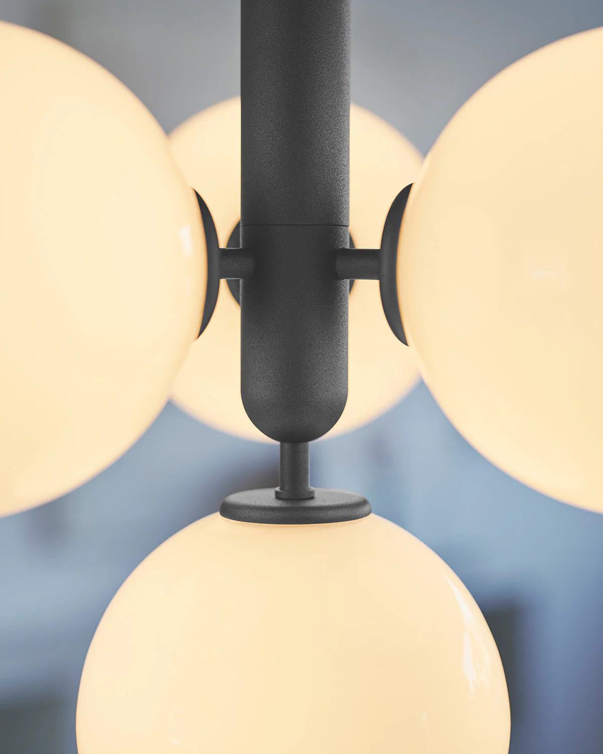 Four-light Scandinavian pendant lamp by Nuura, featuring black frame and opal glass shades for living room , dining room or kitchen lights