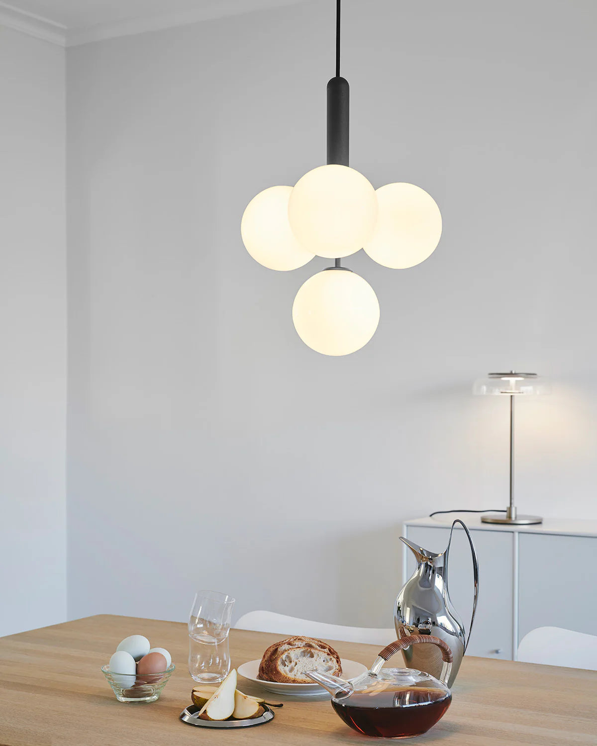 Four-light Scandinavian pendant lamp by Nuura, featuring black frame and opal glass shades for living room , dining room or kitchen lights