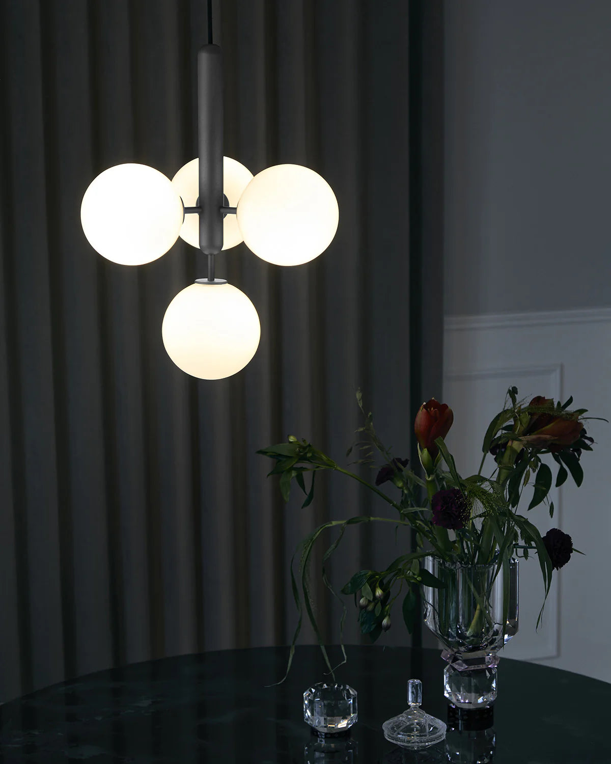 Four-light Scandinavian pendant lamp by Nuura, featuring black frame and opal glass shades for living room , dining room or kitchen lights