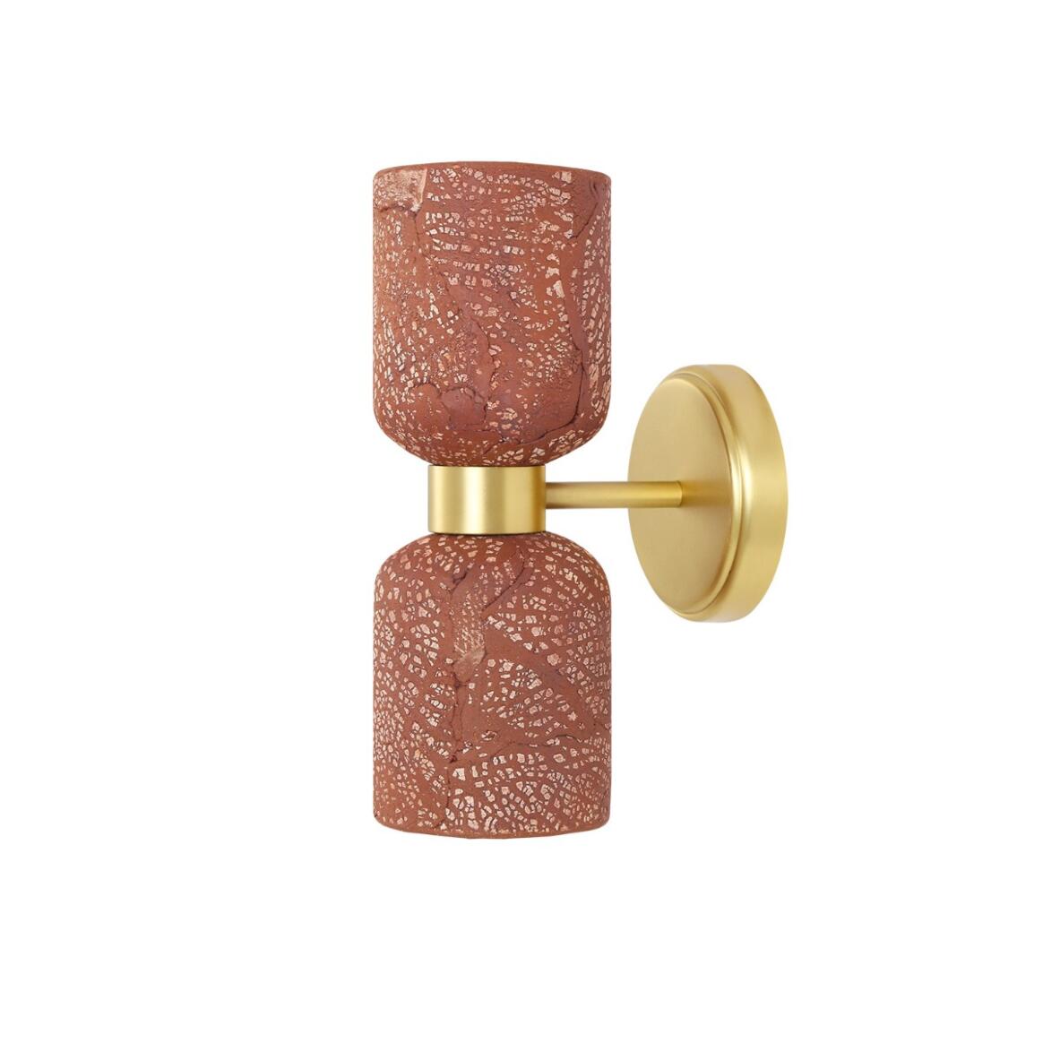 Wall sconce with terracotta-colored glass shades and gold metal arm on a white background
