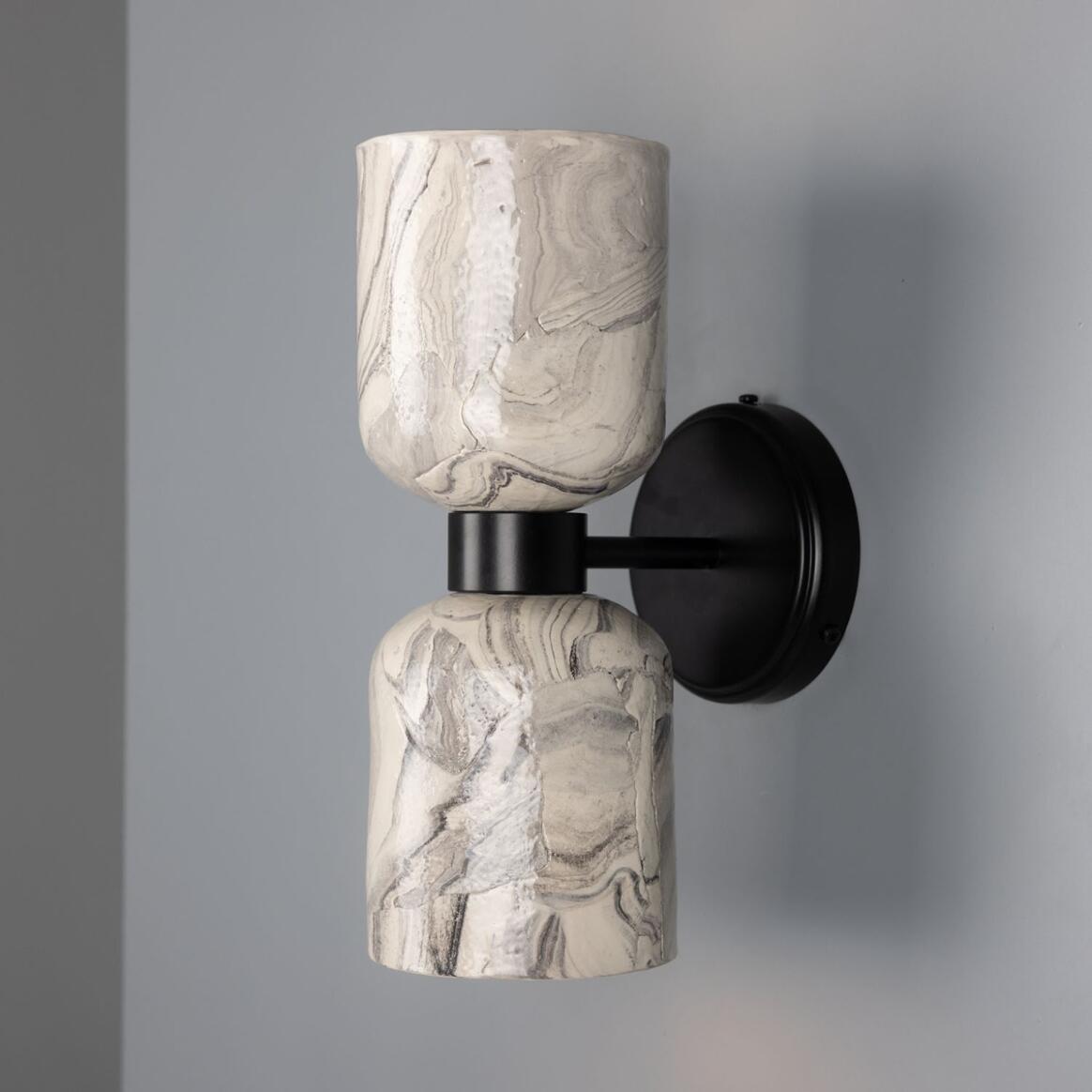 Wall-mounted light fixture with marble-like design on a gray background