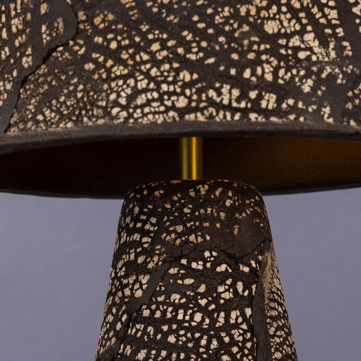 Close-up of a lamp with a patterned shade against a plain background