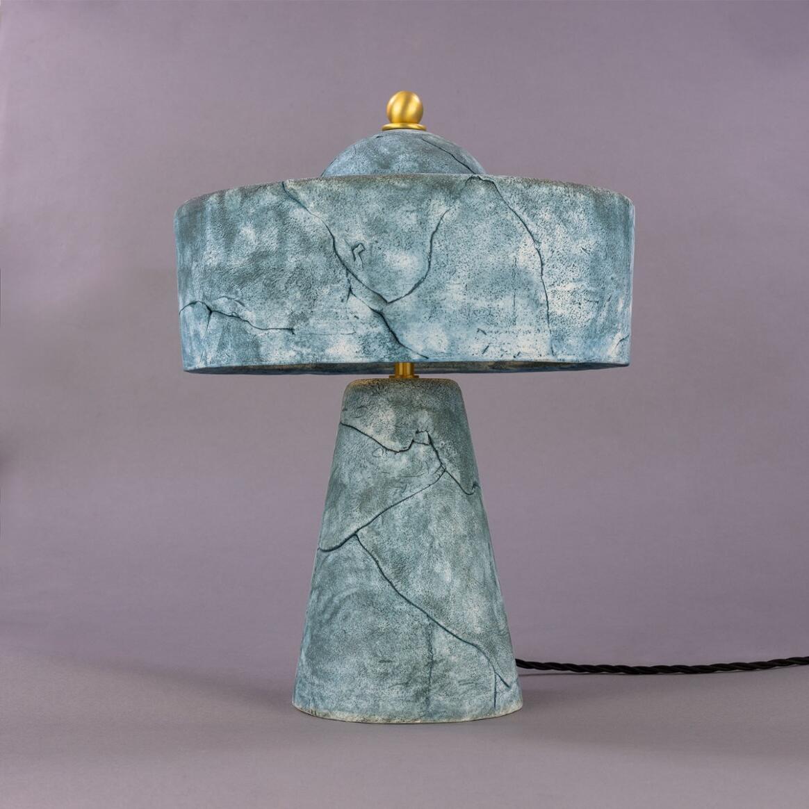 Table lamp with green marble-like finish on a gray background