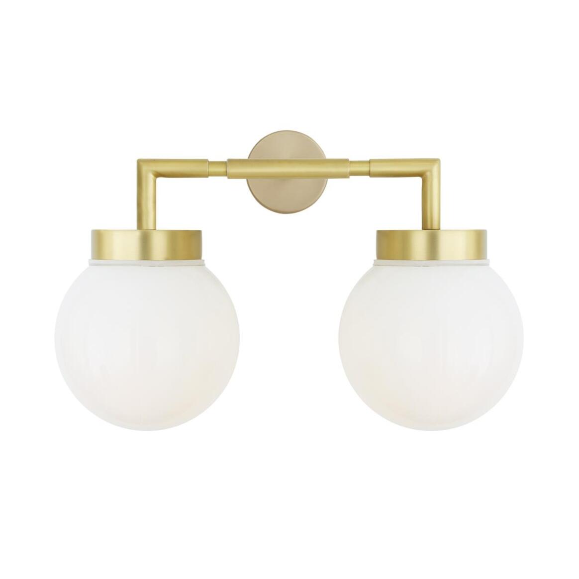Wall-mounted light fixture with gold arm and white glass shades on a white background
