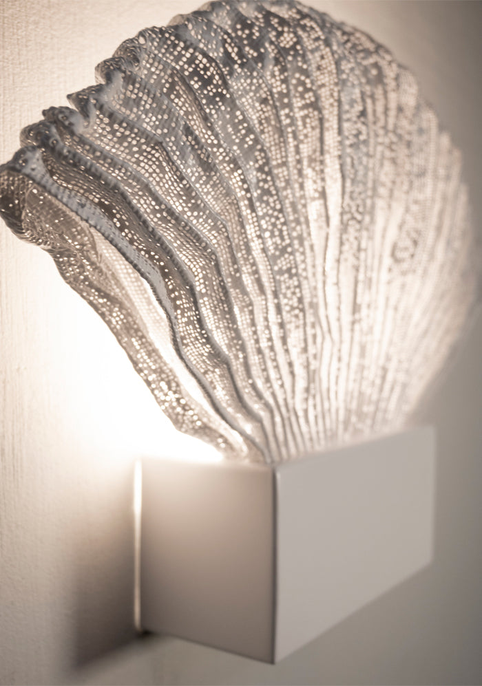 Decorative wall light fixture with textured surface on a neutral background